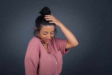 Shot of happy young woman with positive smile, has long hair, rejoices having weekend and good rest after hard working exhausting week, isolated on gray wall.