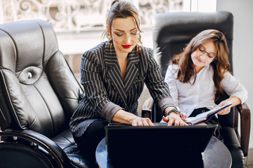 Mother with daughter. Businesswoman at the office. Little girl in a business style