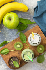 Healthy dieting and nutrition. Vegetarian concept. Blended Green detox vegetable smoothies with organic ingredients on a stone concrete tabletop. Top view flat lay background.