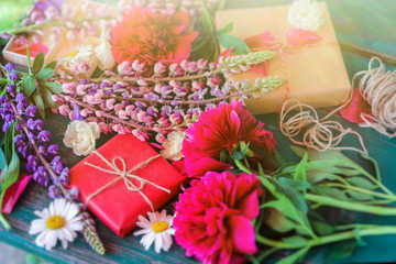 Packing gifts. summer holiday mood. Flowers and gifts on the table.