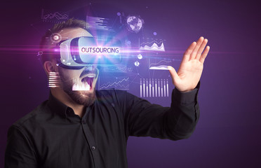 Businessman looking through Virtual Reality glasses with OUTSOURCING inscription, new business concept