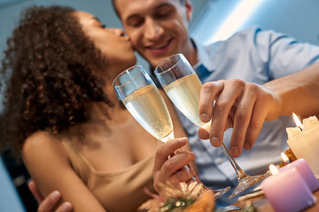 Romantic Date. Young multiethnic couple at home having dinner hugging cheers with champagne...