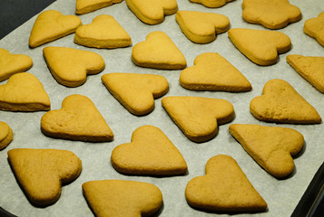 Heart-shaped baked cookies as a Valentine's Day symbol rests on a sheet of grey craft paper