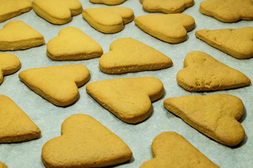 Fototapeta na wymiar Heart-shaped baked cookies as a Valentine's Day symbol rests on a sheet of grey craft paper