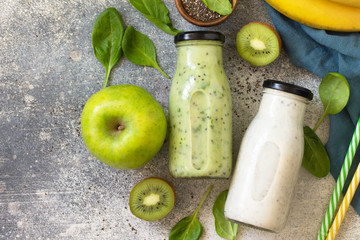 Healthy dieting and nutrition. Vegetarian concept. Blended Green detox vegetable smoothies with organic ingredients on a stone concrete tabletop. Top view flat lay background. Copy space.