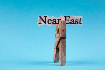 Torn piece of paper with the inscription NEAR EAST on a blue background.