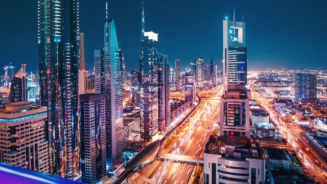 Dubai cityscape timelapse view at evening with illuminated skyscrapers and busy car traffic on the streets. Nightlife concept