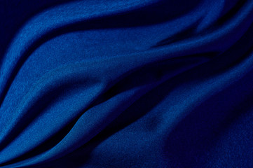 abstract fabric background. waves folds of fabric dark blue color trend 2020