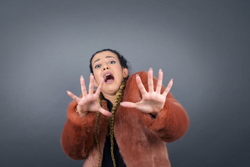Dissatisfied female model frowns face, has disgusting expression, shows tongue, expresses non...