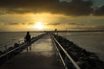 golden rays of sunshine reflect on the pier at sunset