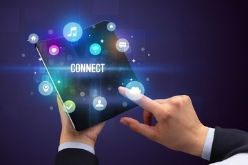 Businessman holding a foldable smartphone with CONNECT inscription, social media concept