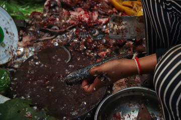 Street fish stall in a market in Cambodia. Girl cleaning fish