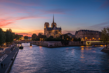 Fototapeta premium Church of Notre Dame de Paris in France before burning fire at sunset on river Seine reflecting lights