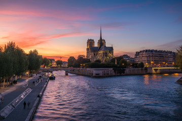 Fototapeta premium Church of Notre Dame de Paris in France before burning fire at sunset on river Seine reflecting lights