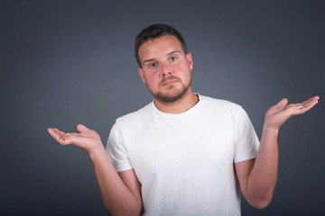 Beautiful man doubt expression, confuse and wonder concept, uncertain future shrugging shoulders,...