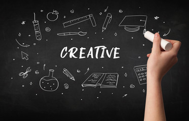 Hand drawing CREATIVE inscription with white chalk on blackboard, education concept