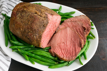 Medium Rare Roast Beef with Green Beans: Sliced medium rare roasted beef eye of round on a platter of green beans