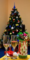  champagne, two glasses of wine, a Christmas tree decorated in the background