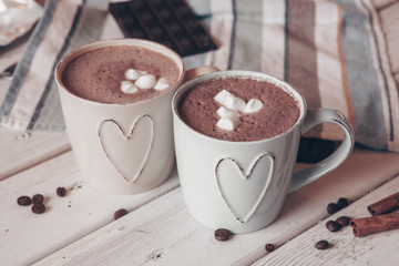 Two cups of hot cocoa with marshmallows and cinnamon sticks on wooden background. Love. Cocoa...