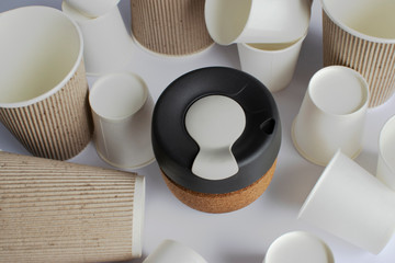 Reusable Coffee Eco Cup. Toughened Glass Cup & Natural Cork Band. Secure silicon lid. Reusable eco cup on the background of disposable cups. Eco-Friendly, Spill Proof Travel Mug with Lid | Black