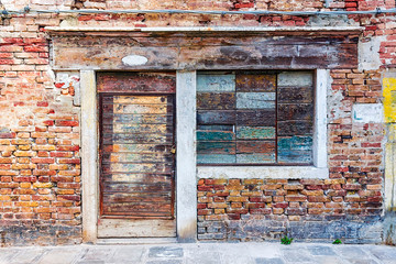 Old brick facade with boarded up windows.