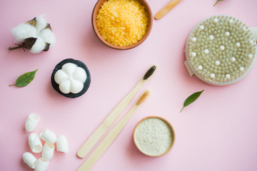 Cosmetic bath salt, grape gomaj for the face, coffee scrub for the body on a pink background.
