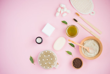 Cosmetic bath salt, grape gomaj for the face, coffee scrub for the body on a pink background.