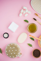 Cosmetic bath salt, grape gomaj for the face, coffee scrub for the body on a pink background.