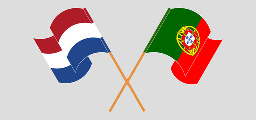 Crossed and waving flags of Portugal and the Netherlands