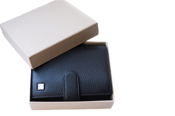There is an opened gift box with a good, expensive wallet made of black genuine leather lies on the white background. Stylish accessory as a gift for a businessman.