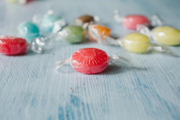 Heap of colorful sugar candies on wooden background. Close up view of fruity candies as texture and background.