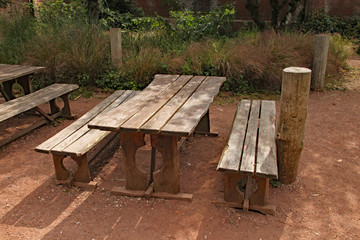 A rustic picnic table and bench in a playground