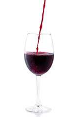 Pouring red wine in glass isolated on white background