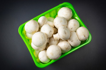 Mushrooms in packing on a dark background close up.