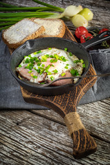 Fried eggs with ham on an old wooden background.