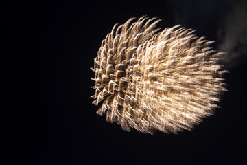 abstract texture of dancing light gold fireworks on a black background with copy space