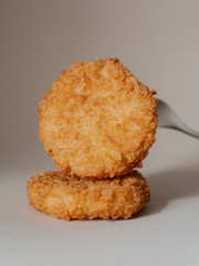 food, fried chicken medallions breaded, on a fork