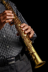 Obraz premium soprano saxophone in hands on a black background
