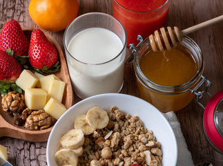 healthy breakfast with milk, muesli, honey and strawberries 