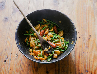 Meat, potatoes and vegetables cooked in a wok. Top view