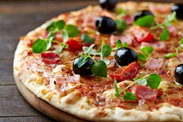 Pizza with ham, mozzarella cheese, cherry tomatoes, black olives and fresh oregano. Home made food....