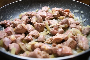 meat poultry diced roasted in the pan with the onion cooking process in the kitchen