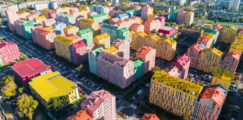 Urban landscape of colorful buildings. Aerial view of the colorful buildings in the European city in the morning sunlight. Cityscape with multicolored houses, cars on the street in Kiev, Ukraine.