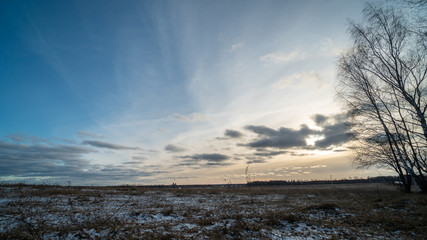 Obraz premium Beautiful setting sun over frozen field