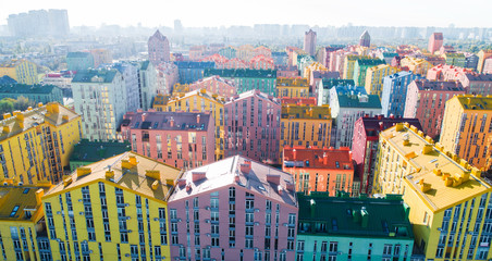Urban landscape of colorful buildings. Aerial view of the colorful buildings in the European city in the morning sunlight. Cityscape with multicolored houses, cars on the street in Kiev, Ukraine.