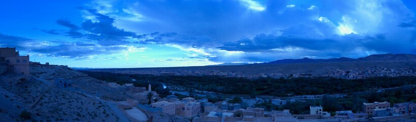 Town before green gorge with palm trees, surrounded by desert, Morocco, Africa