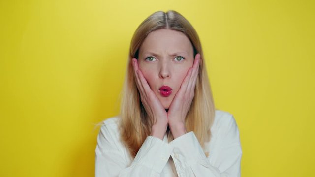 Portrait girl on a yellow background. The girl&rsquo;s emotion shows what a nuisance, how it happened, ah ah ah.