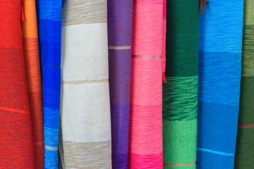 Pieces of fabric and textiles in a factory shop. Multi different colors and patterns on the market.