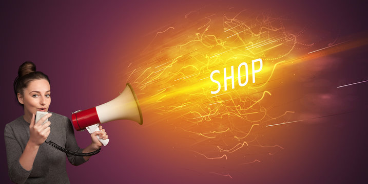 Young girld shouting in megaphone with SHOP inscription, online shopping concept