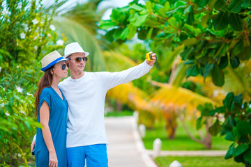 Happy couple taking a photo on white beach on honeymoon holiday